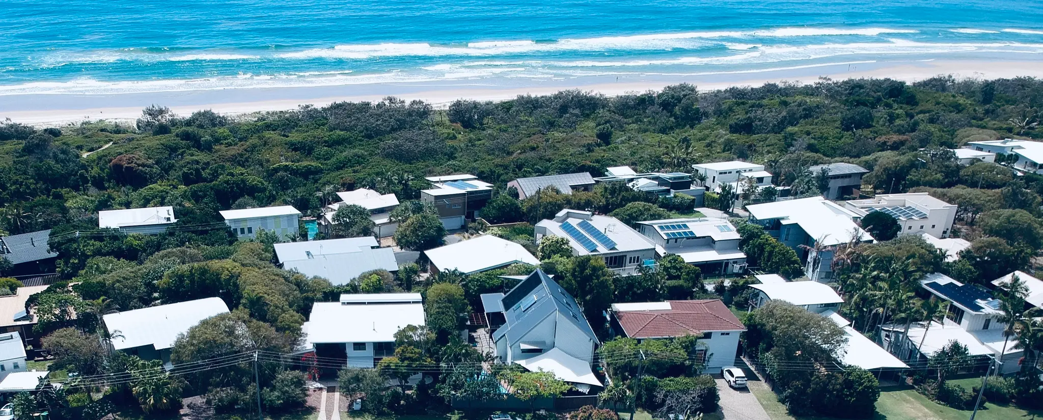 A Sunshine Coast beach and the homes behind it, seen from the air