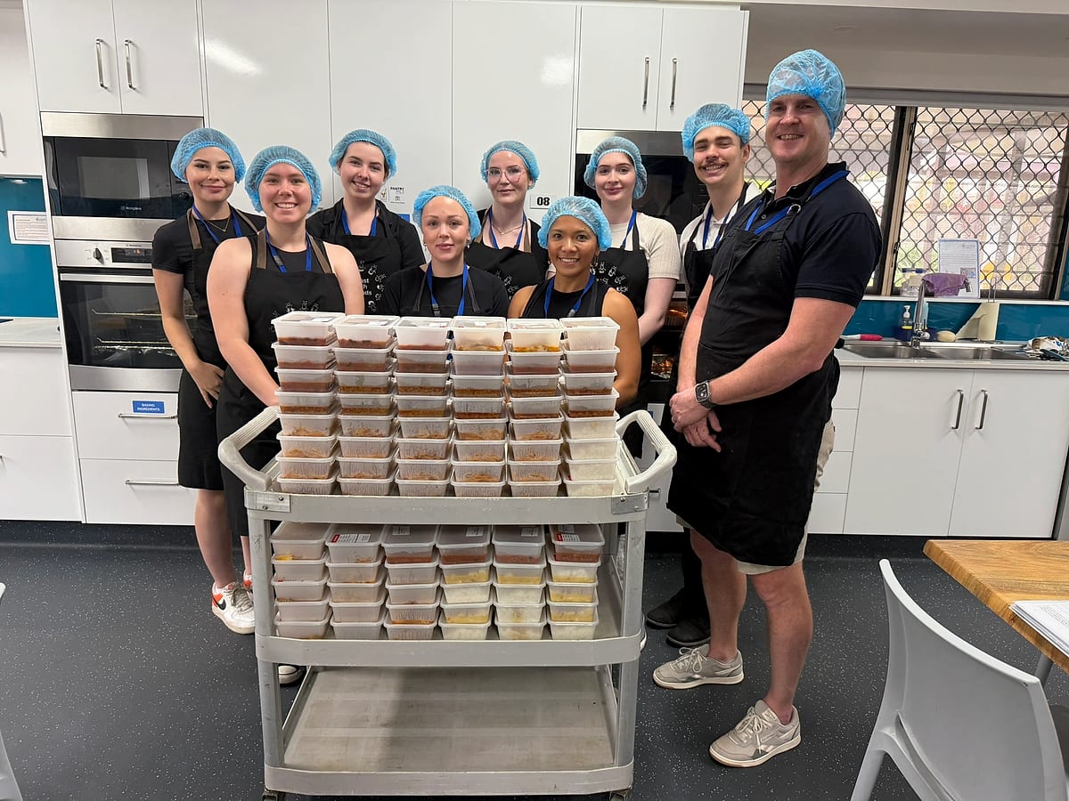 Smart Rentals team in the Townsville Ronald McDonald House kitchen with the meals they cooked for families, December 2024